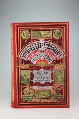 Jules Verne : César Cascabel. Paris, Hetzel, sd (1890, catalogue FN). Un volume grand in-8° relié pleine percaline d'éditeur à décor, cartonnage aux deux éléphants sur fond rouge. Bel intérieur presque sans rousseurs. Quelques marques du temps dont un plis au frontispice. Le cartonnage est très frais. Très bel exemplaire. Collection Hetzel!
