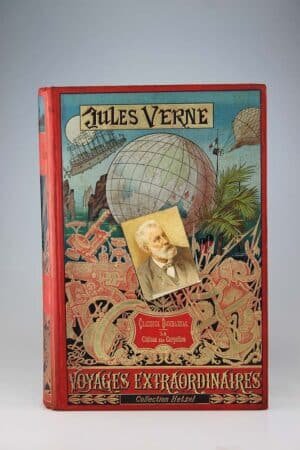 Jules Verne : Claudius Bombarnac & Le château des Carpathes. Paris, Hetzel, sd, (1892, catalogue GK). Un volume grand in-8° relié pleine percaline d’éditeur à décor, cartonnage au portrait collé. Rousseurs très intenses, surtout en début et fin d'ouvrage. Quelques marques du temps. Cartonnage très frais. Bel exemplaire de premier tirage. Collection Hetzel, dos au phare!